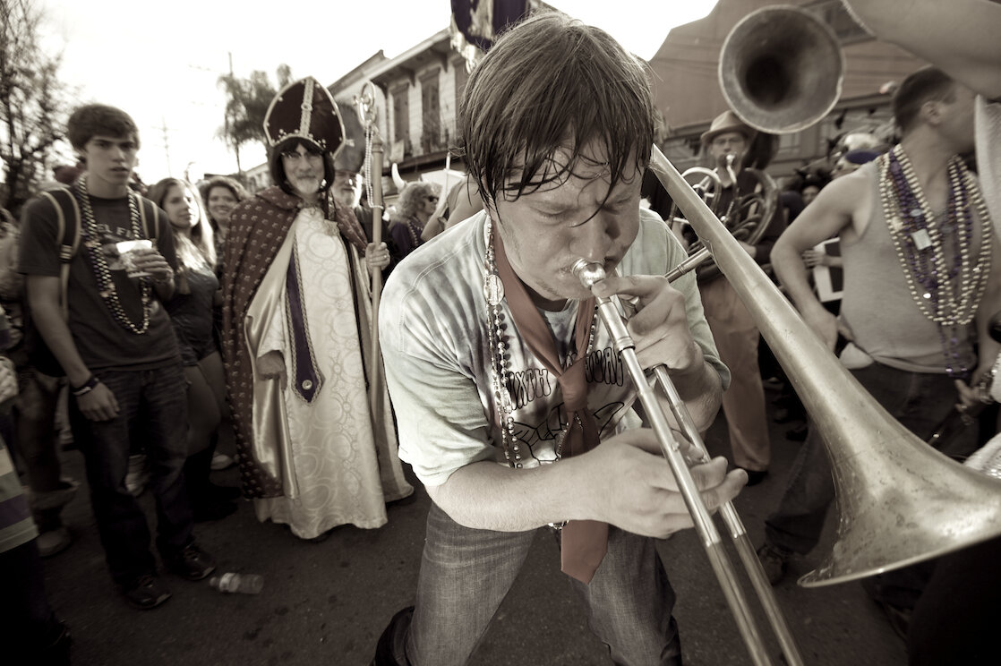 Member of Lagniappe Brass Band plays his trombone during a parade. Photo ©Marc Pagani Photography