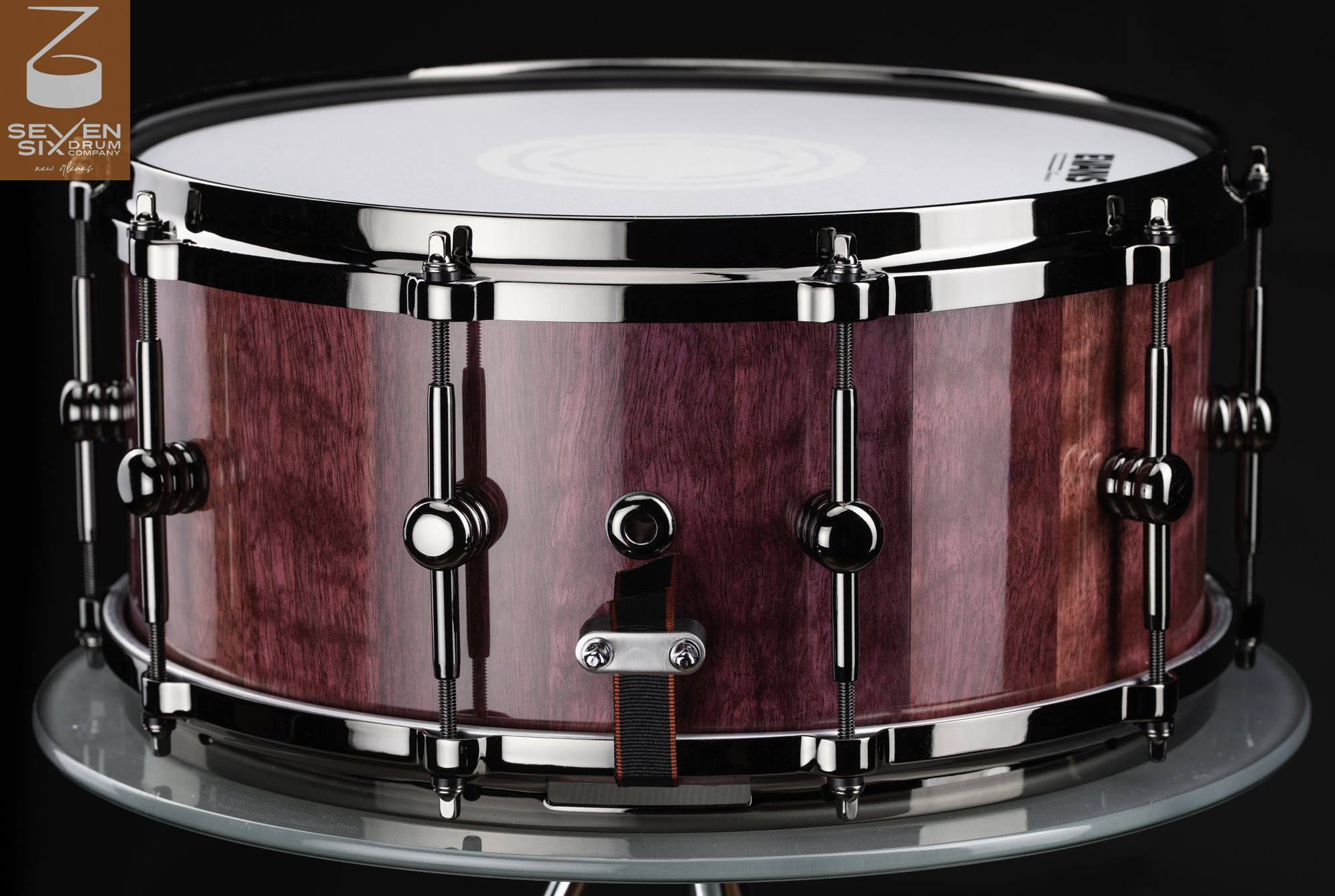 Purpleheart wood stave snare drum with a high-gloss finish, chrome hoops, and polished center-point lugs.