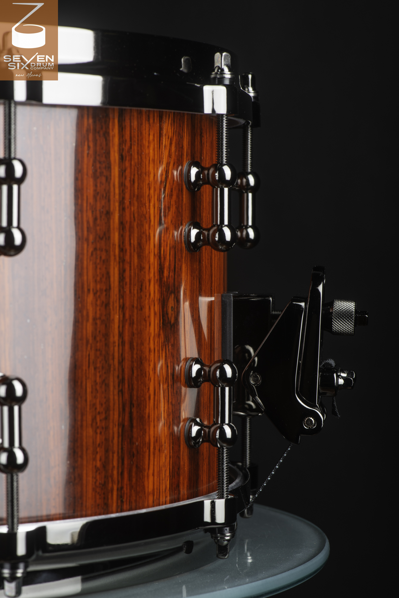 Glossy red wood snare drum featuring polished black nickel tube lugs and a matching snare throw-off.