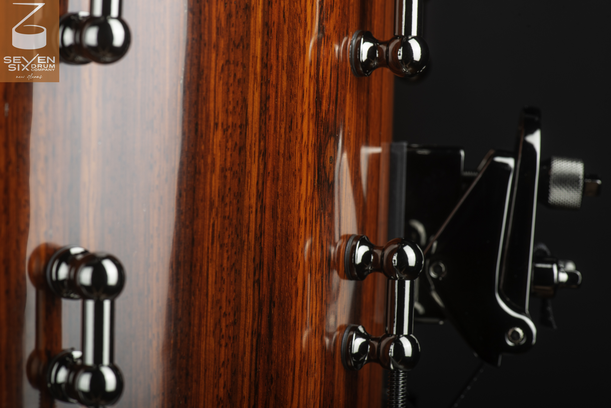 Snare drum shell with a glossy red wood grain finish, chrome tube lugs, and a black snare throw-off.