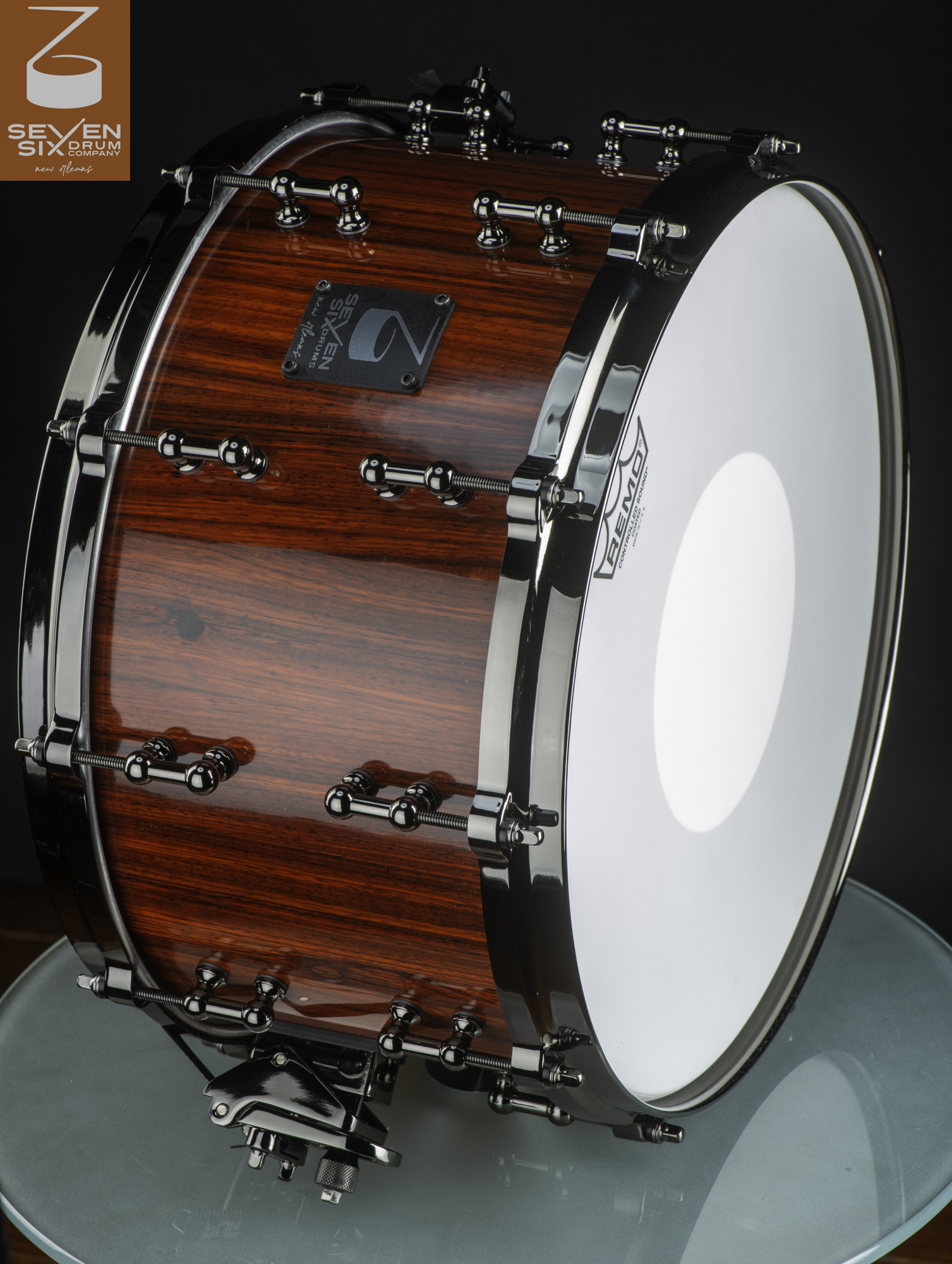 Handmade deep snare drum with a glossy red wood finish, featuring black nickel hoops and tube lugs.