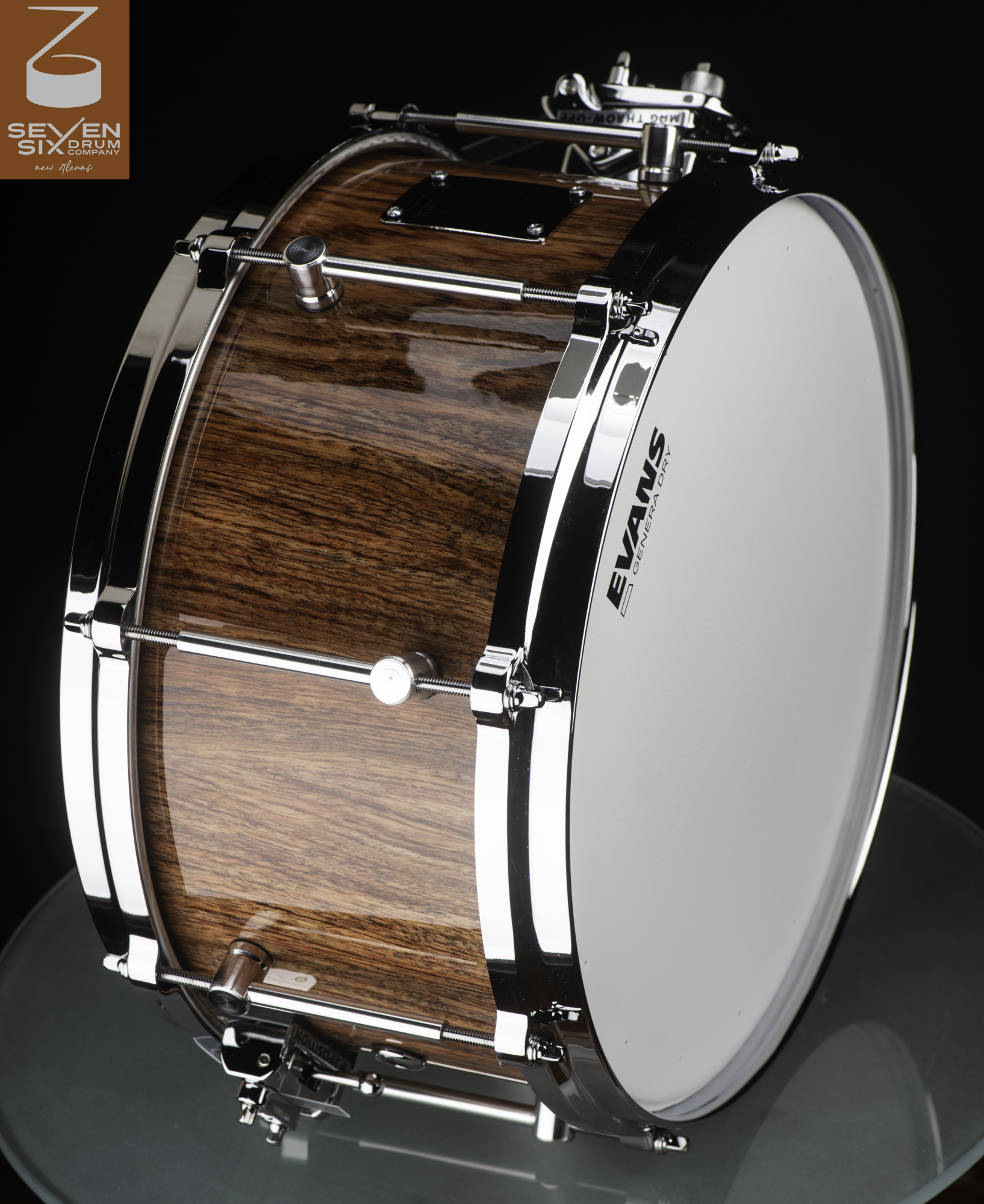 Handmade snare drum with a high-gloss wood grain shell, polished chrome hoops, and single-point lugs.