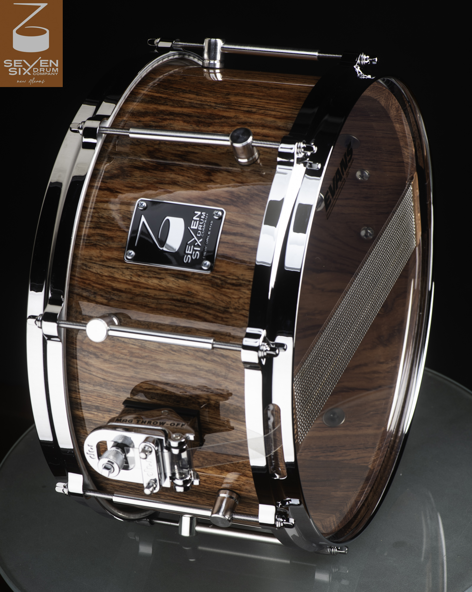 Handmade wooden snare drum with a high-gloss wood grain finish, chrome hoops, tube lugs, and a MAG throw-off.