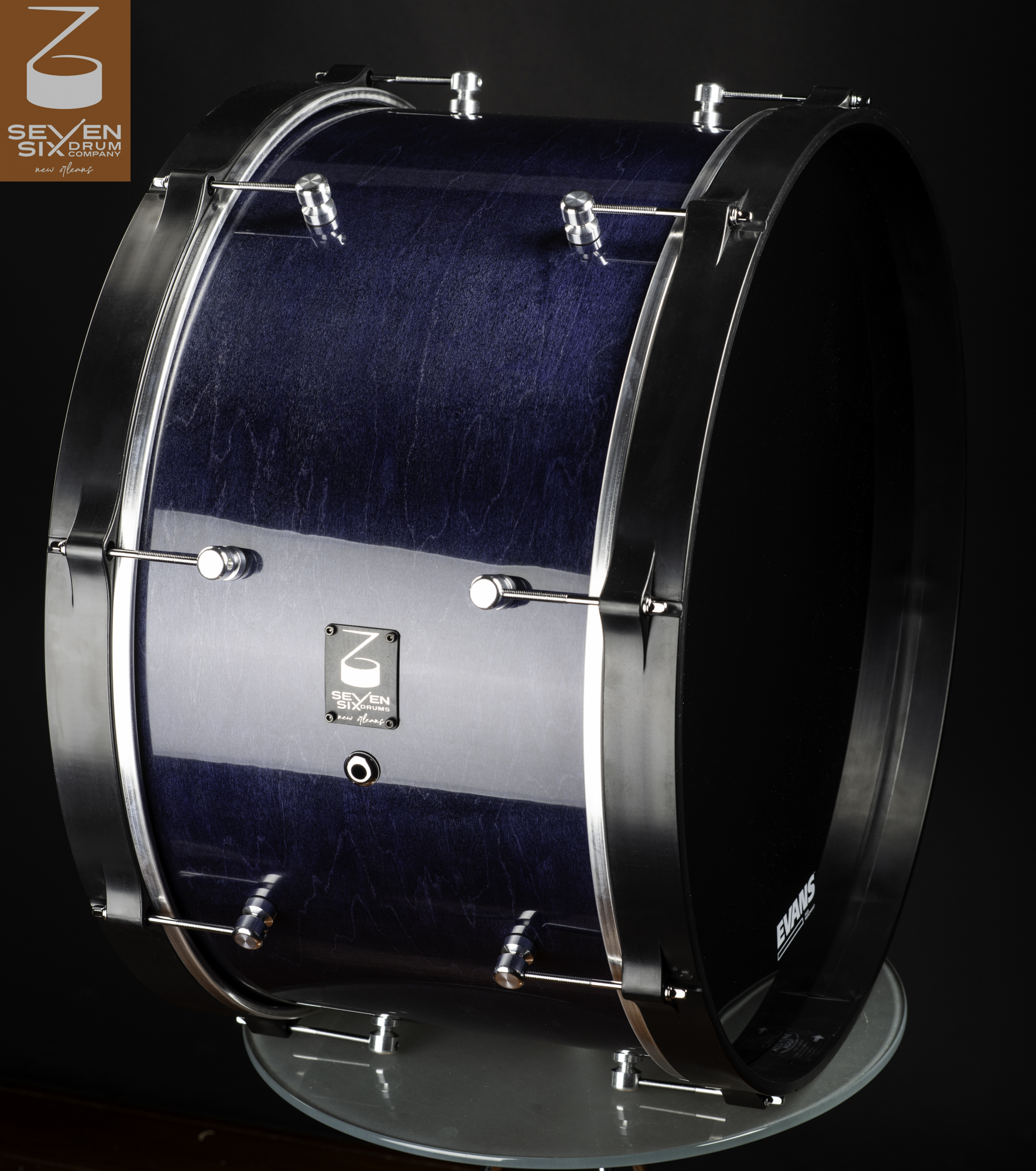Glossy blue stained wood bass drum with matte black hoops and polished chrome lugs.