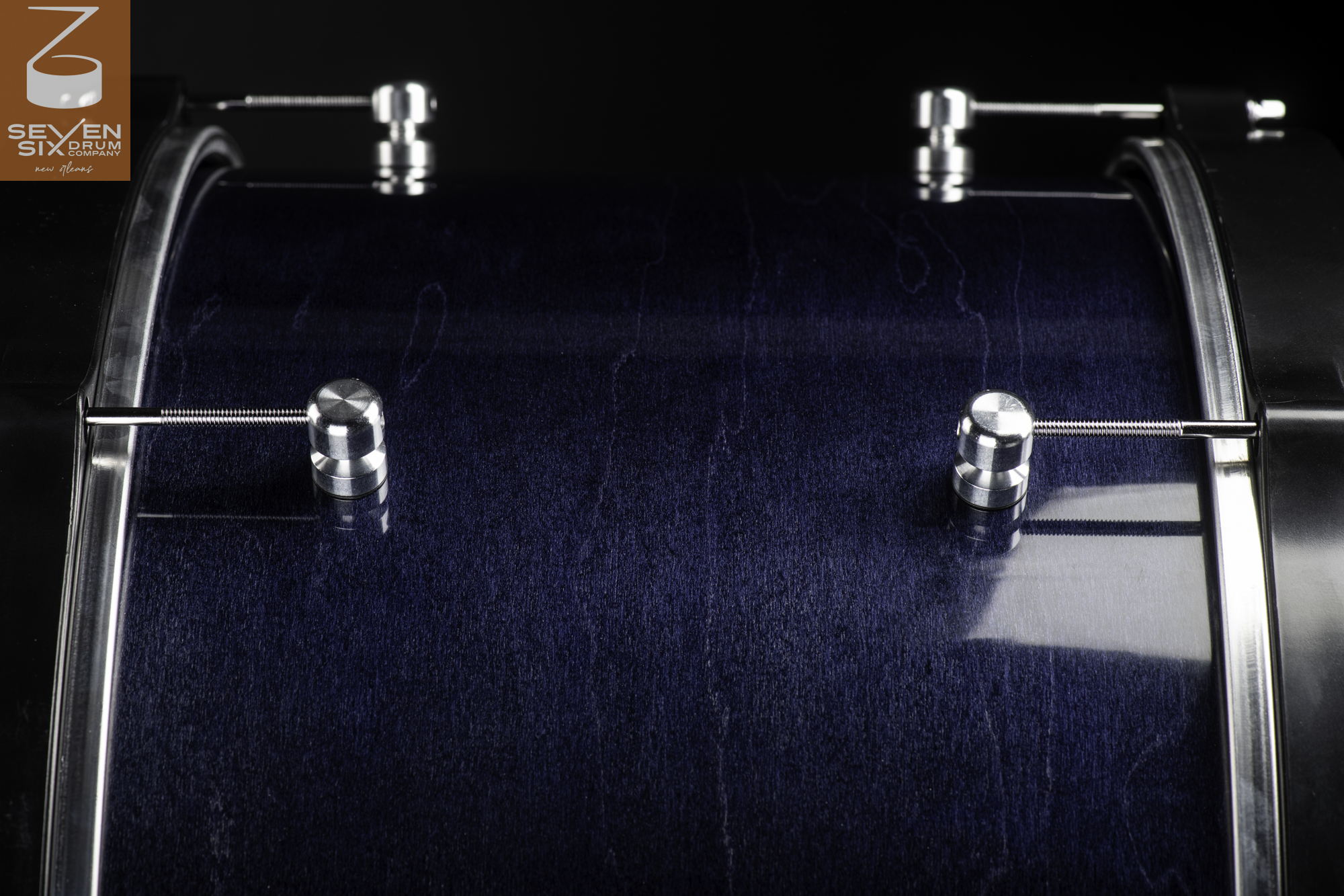 Handmade snare drum featuring a glossy dark blue wood grain shell, round chrome lugs, and steel hoops.