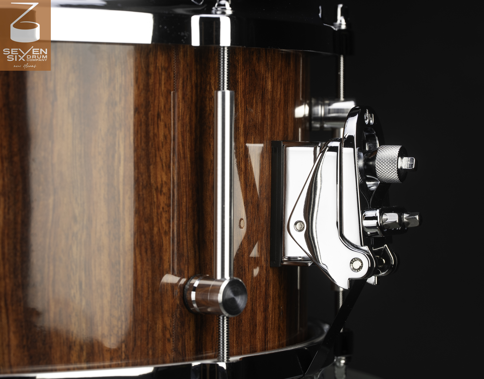 Handmade snare drum with a high-gloss wood finish, chrome hoops, and a polished snare throw-off strainer.