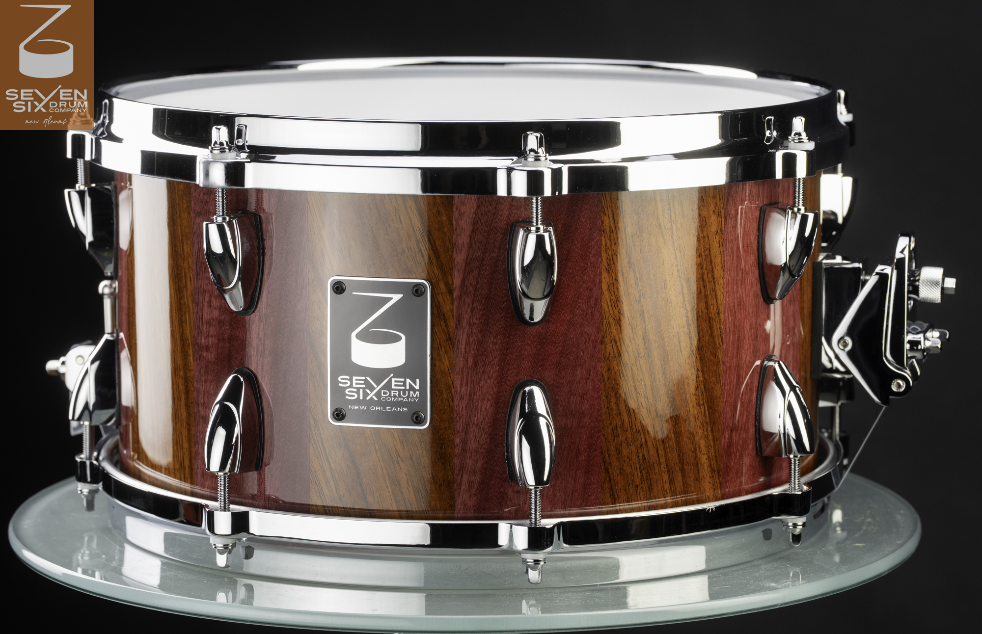 Handmade snare drum with a high-gloss striped wood shell, chrome teardrop lugs, and matching chrome hoops.
