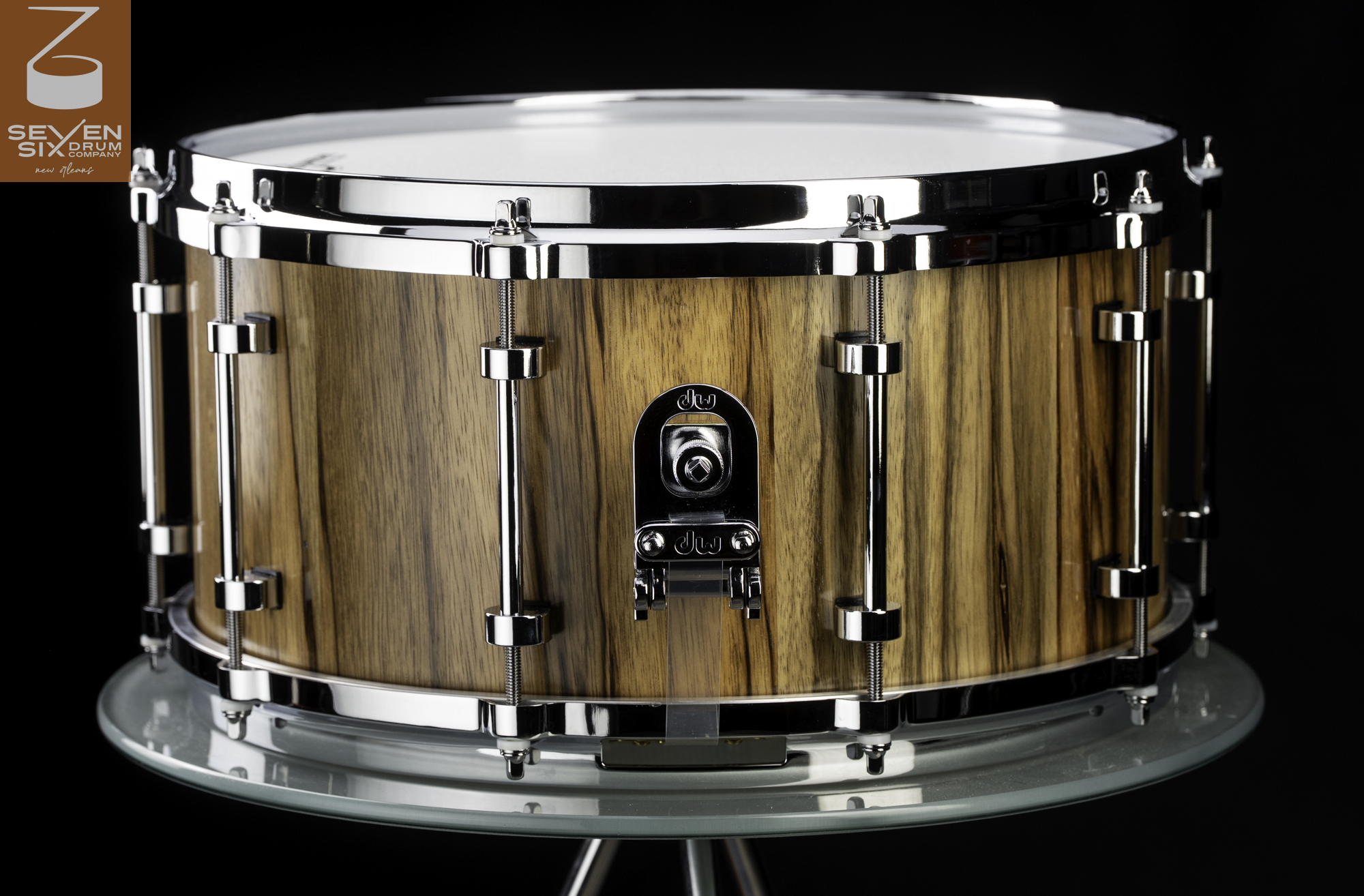 Handmade snare drum with a natural vertical wood grain finish, chrome tube lugs, and a DW butt plate.