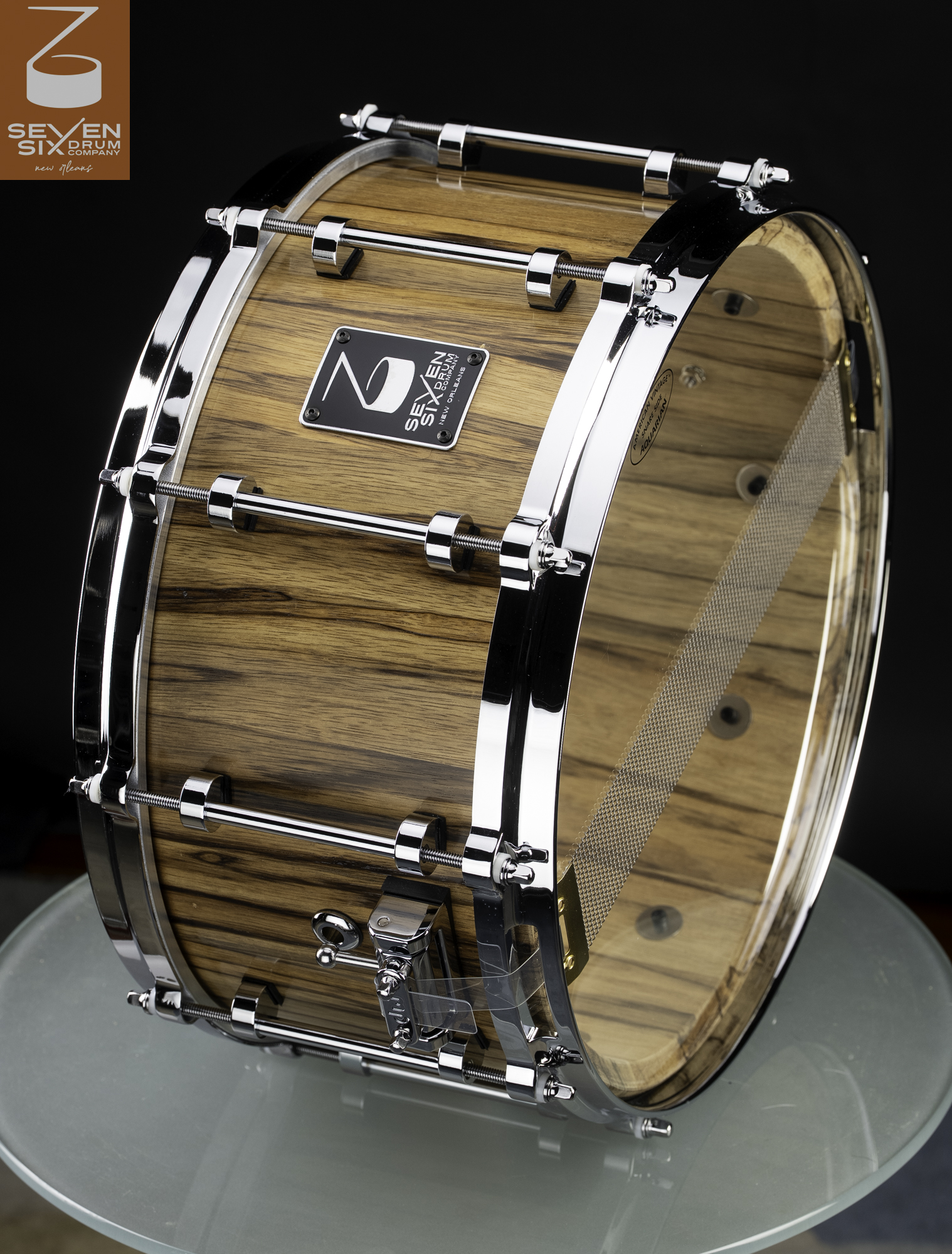 Handmade snare drum with a natural striped wood shell, clear finish, polished chrome tube lugs, and chrome hoops.