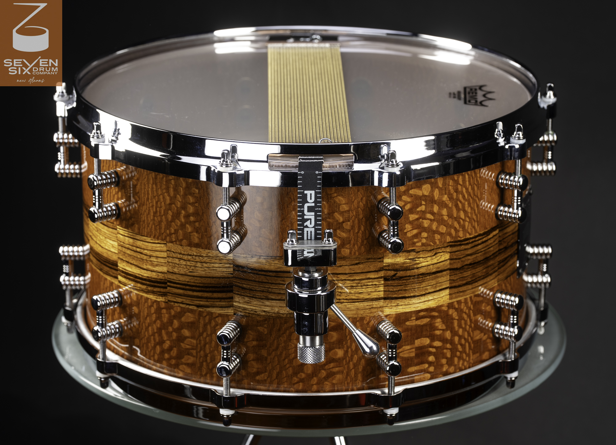 Handmade snare drum with a glossy lacewood and zebrawood shell, chrome hardware, and snare throw-off.