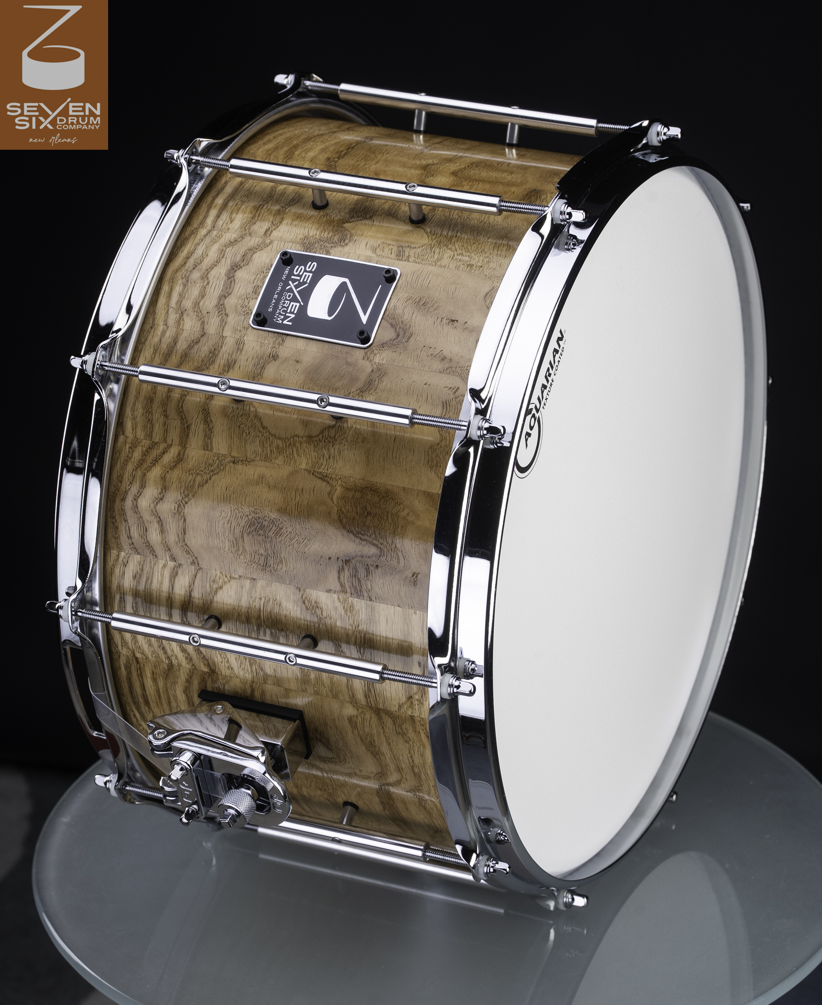 Handmade snare drum in natural finish segmented wood with polished chrome tube lugs, hoops, and strainer.