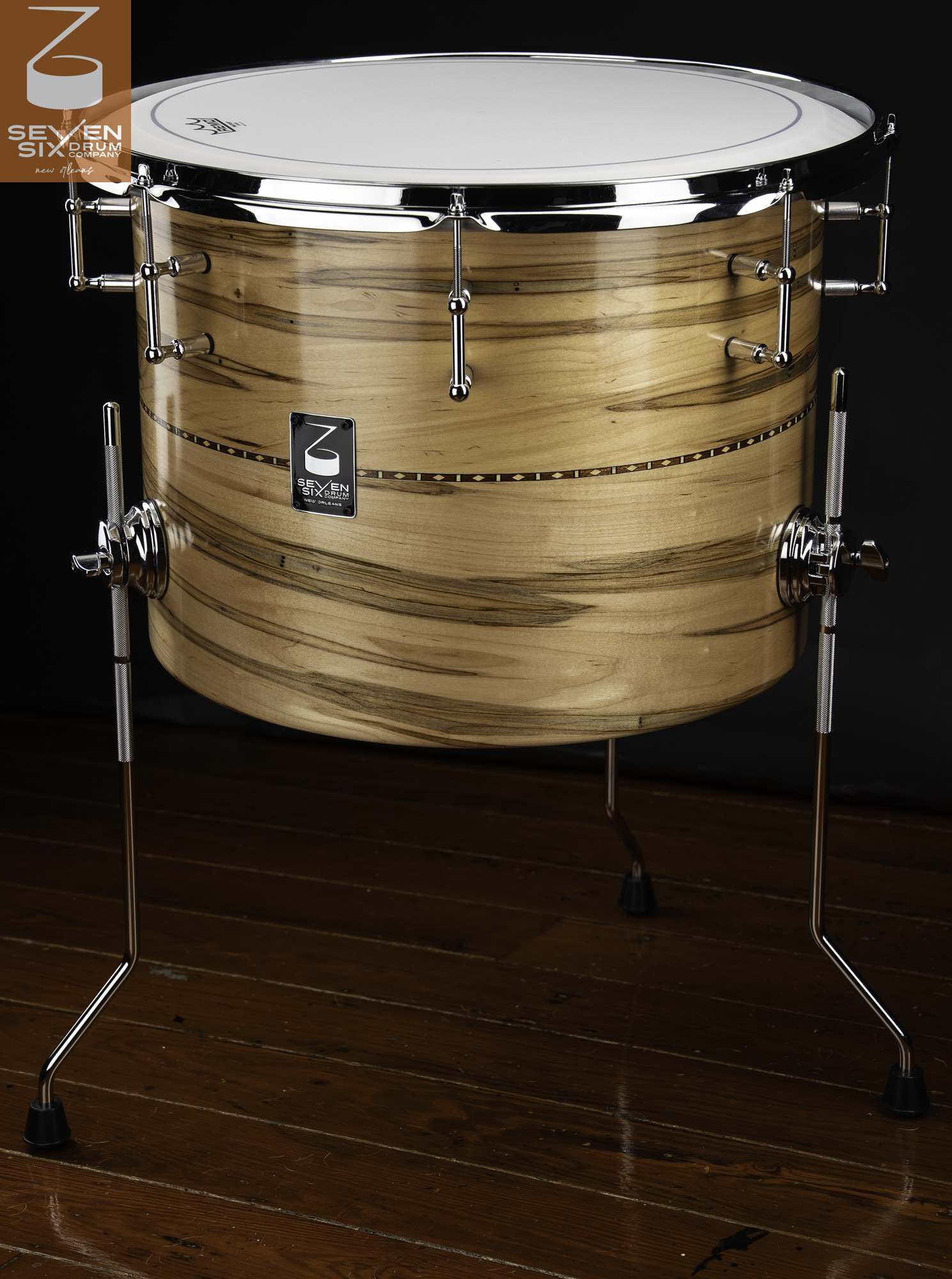 Glossy natural wood floor tom with a decorative inlay band, chrome tube lugs, and chrome floor legs.