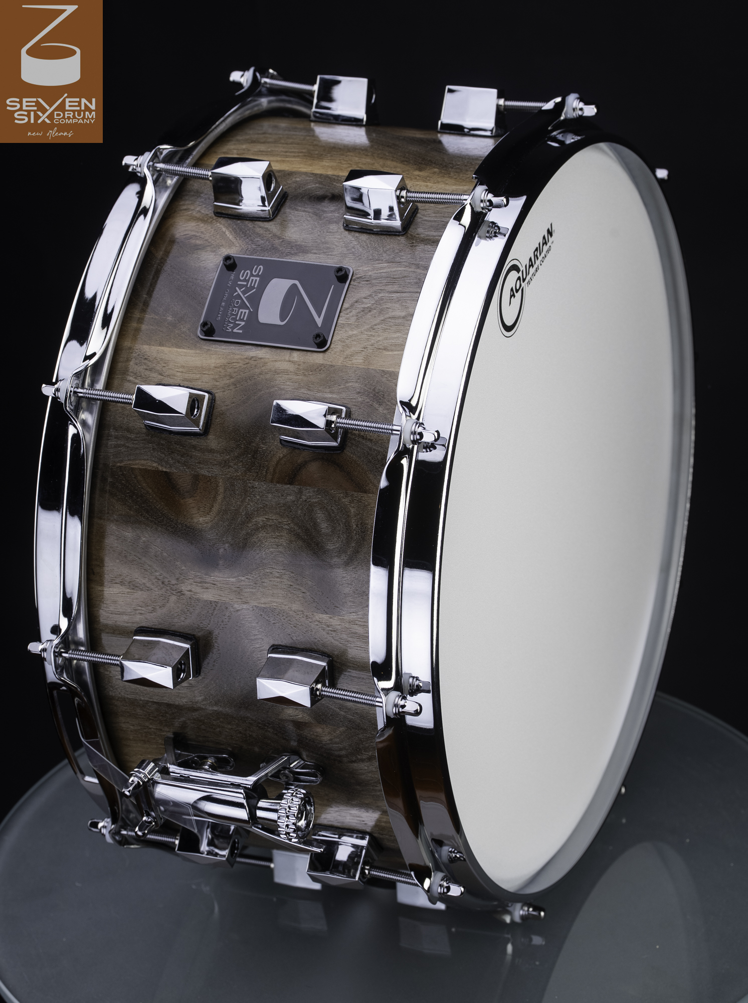 Handmade snare drum with a natural walnut wood shell, chrome lugs, and a chrome snare throw-off.
