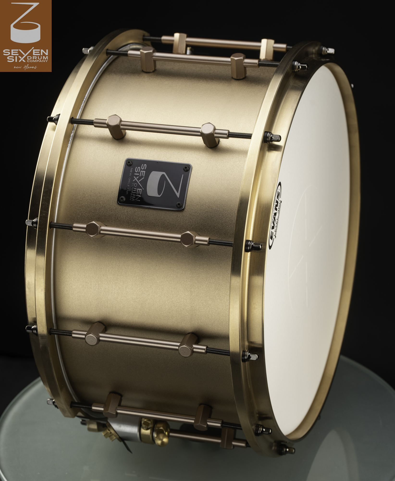 Deep snare drum featuring a matte bronze finish, matching solid metal hoops, and sleek tube lugs.