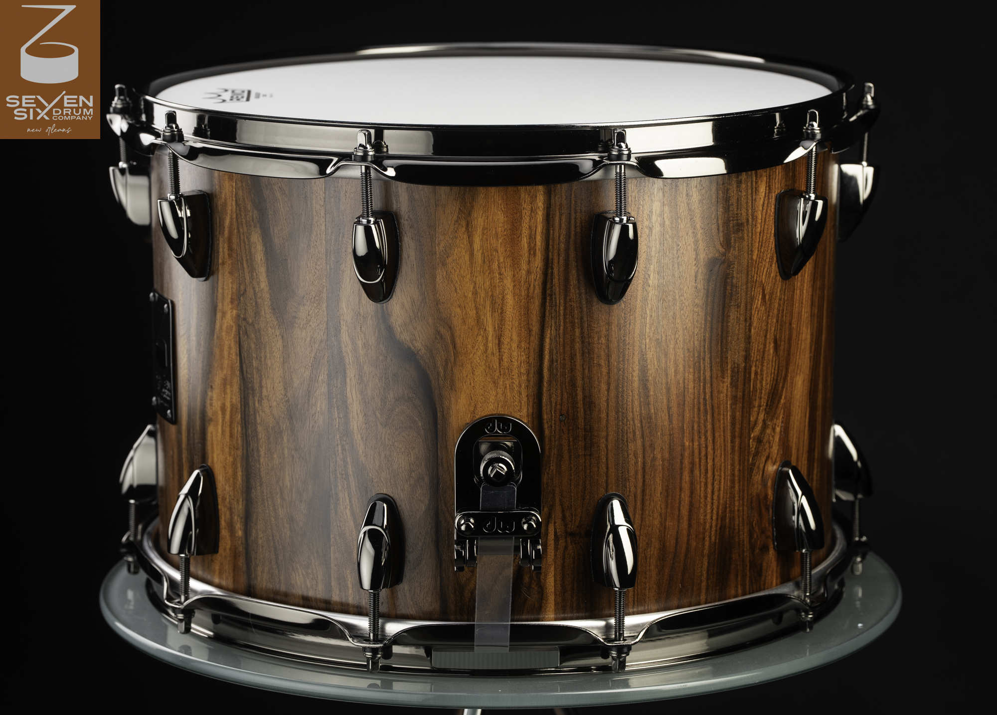 Deep wooden snare drum with a natural vertical grain finish, black nickel hoops, teardrop lugs, and a snare throw-off.
