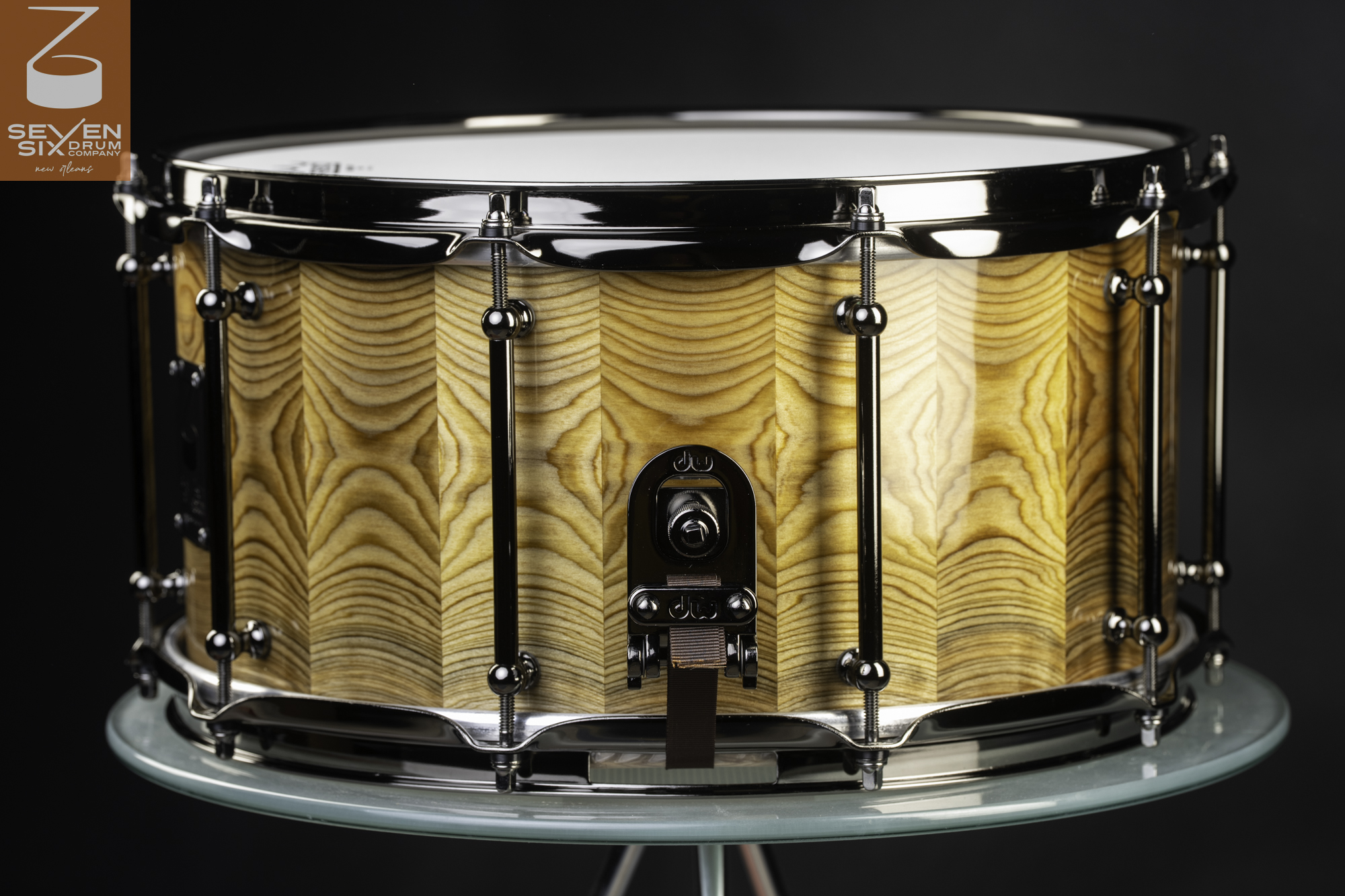 Handmade snare drum featuring a glossy faceted wood shell with black nickel tube lugs and a DW throw-off.