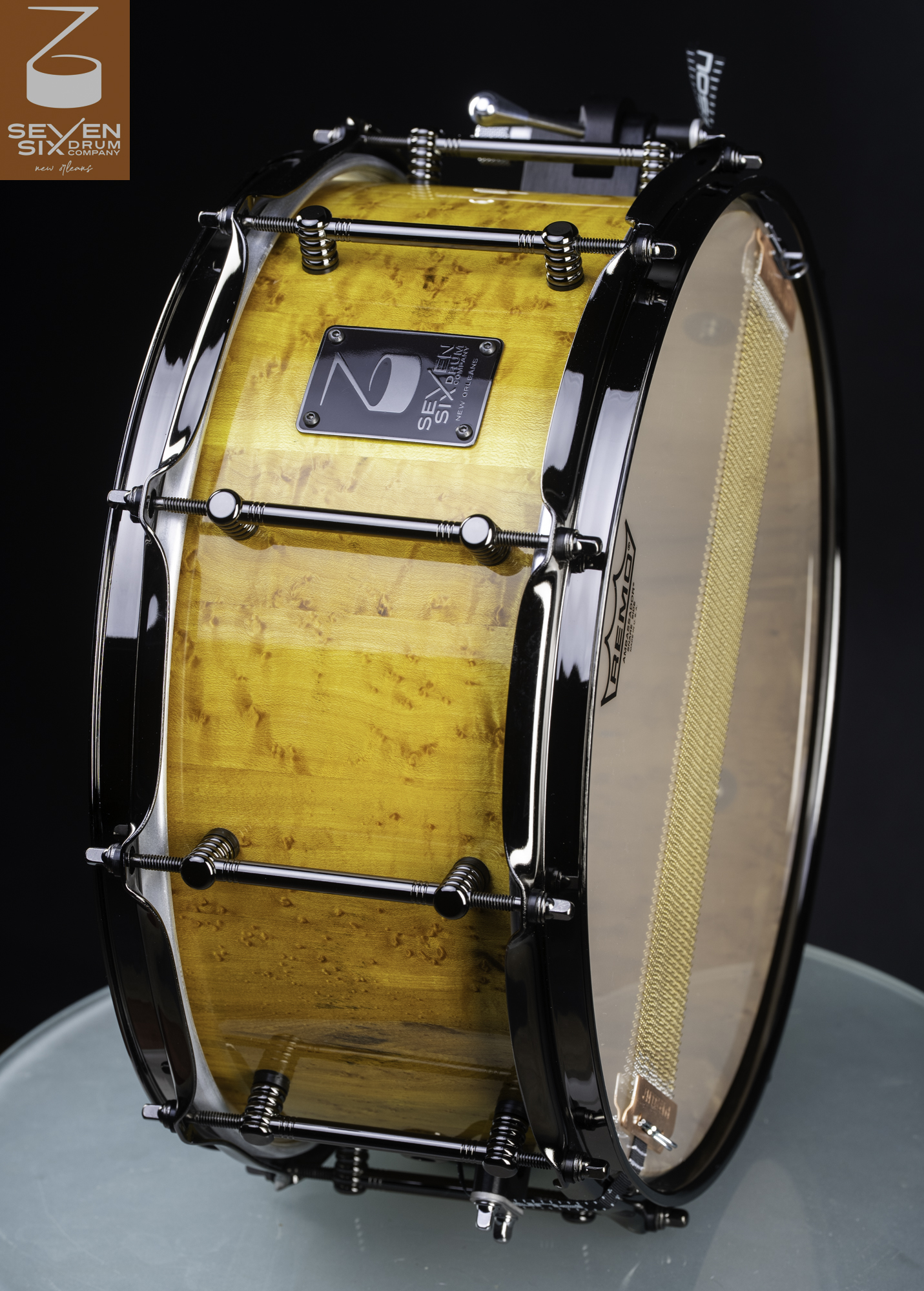 Handmade snare drum featuring a gloss golden birdseye maple shell with black nickel hoops and tube lugs.