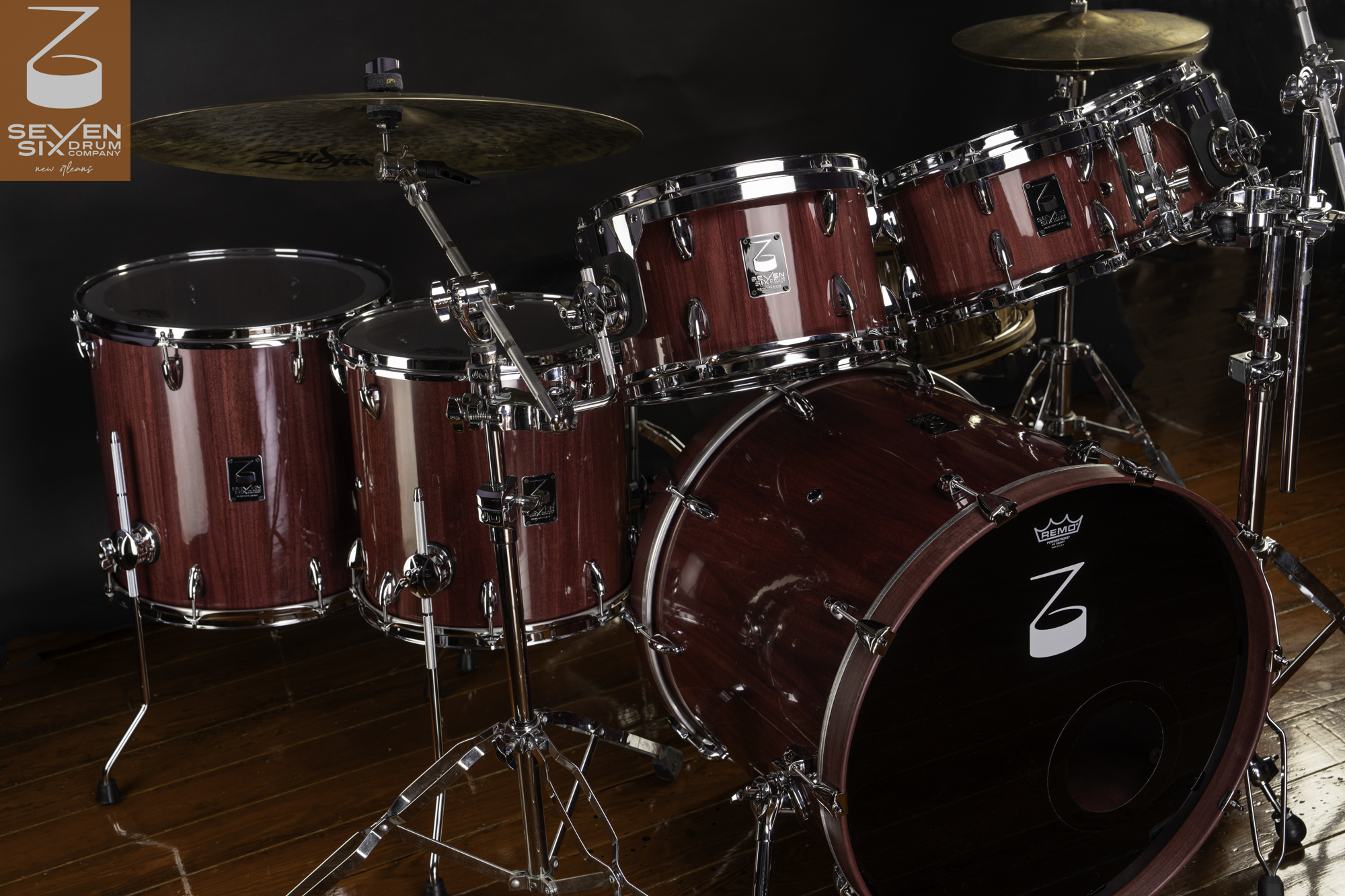 Custom drum set in a glossy purple wood finish with polished chrome hardware, rims, and cymbal stands.