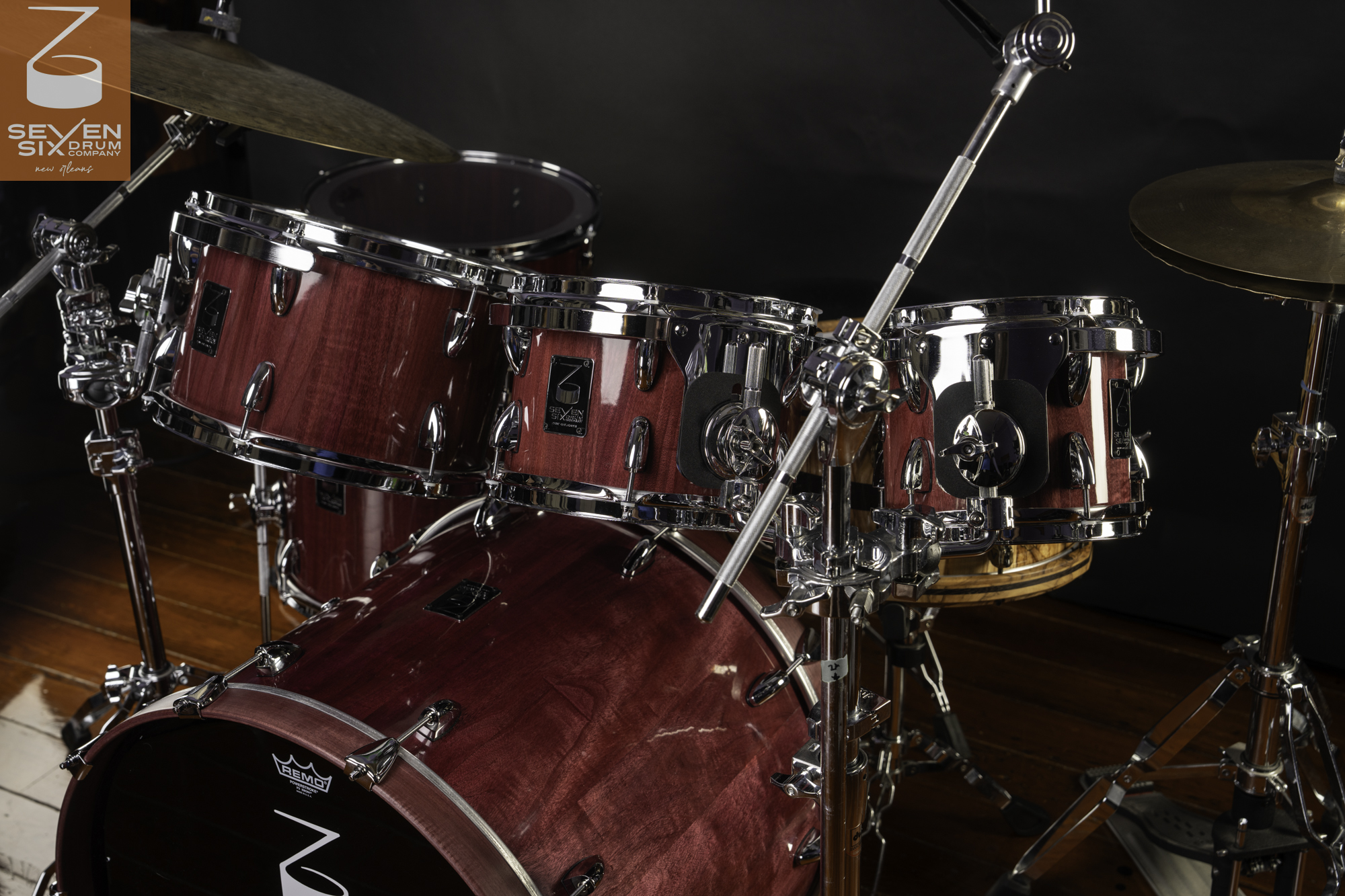 Handmade drum kit featuring glossy purple-stained wood shells and polished chrome hardware.